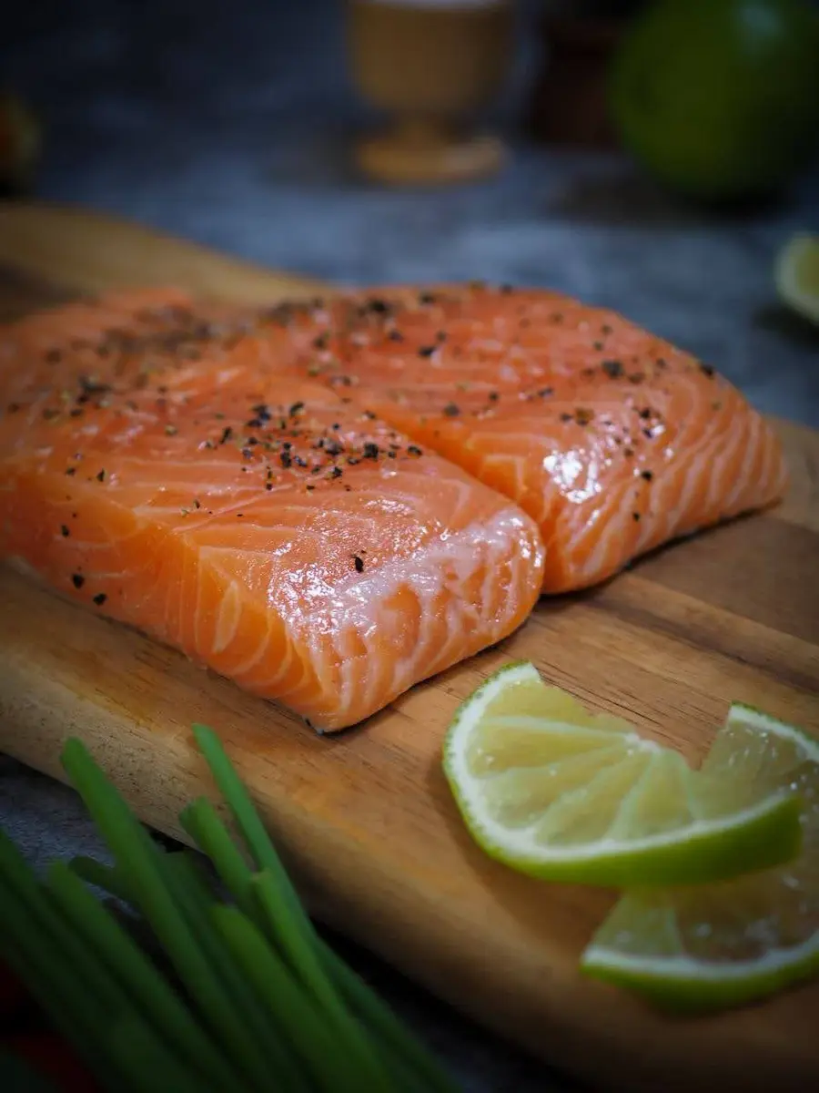 Fresh raw salmon fillets seasoned with pepper and lime